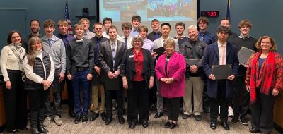 Wilsonville High School basketball players and coaches posing with the City Council in Council Chambers. 