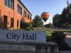 A hot air balloon flies over Wilsonville behind City Hall